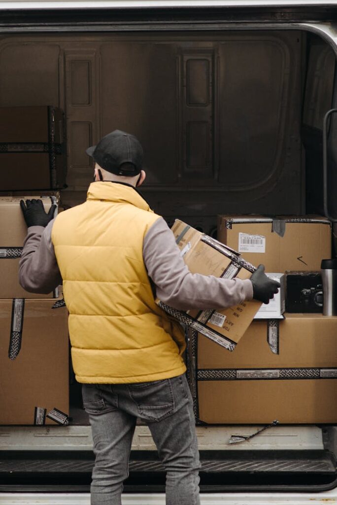 pexels photo 6407531 Deliveryman organizing packages into a van for distribution.